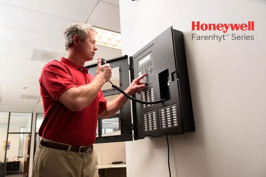 Man in Red shirt working on fire panel Farenhyt logo