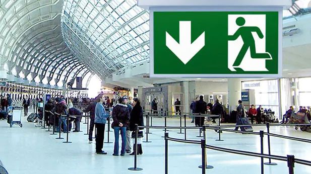 intevio-an airport concoourse with an emergency exit sign