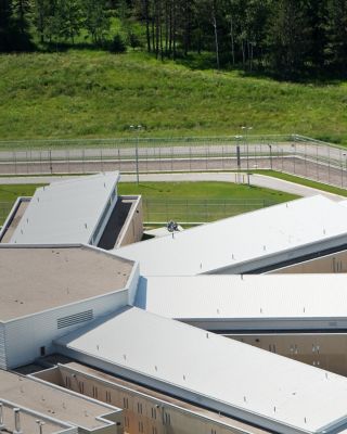 A modern podular prison cell block aerial view. The pod with wings decentralizes prisoners into smaller groups for easier control. Outdoor areas are separated to prevent large gatherings of prisoners. http://www.banksphotos.com/LightboxBanners/Aerial.jpg