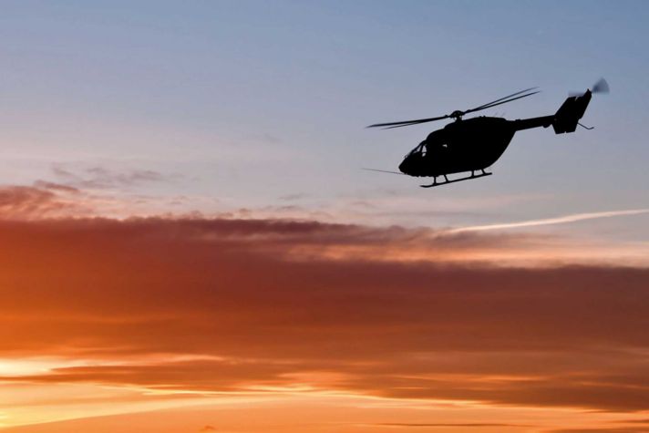 Helicopter flying into sunset
