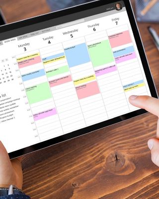 Man using calendar app on tablet in office