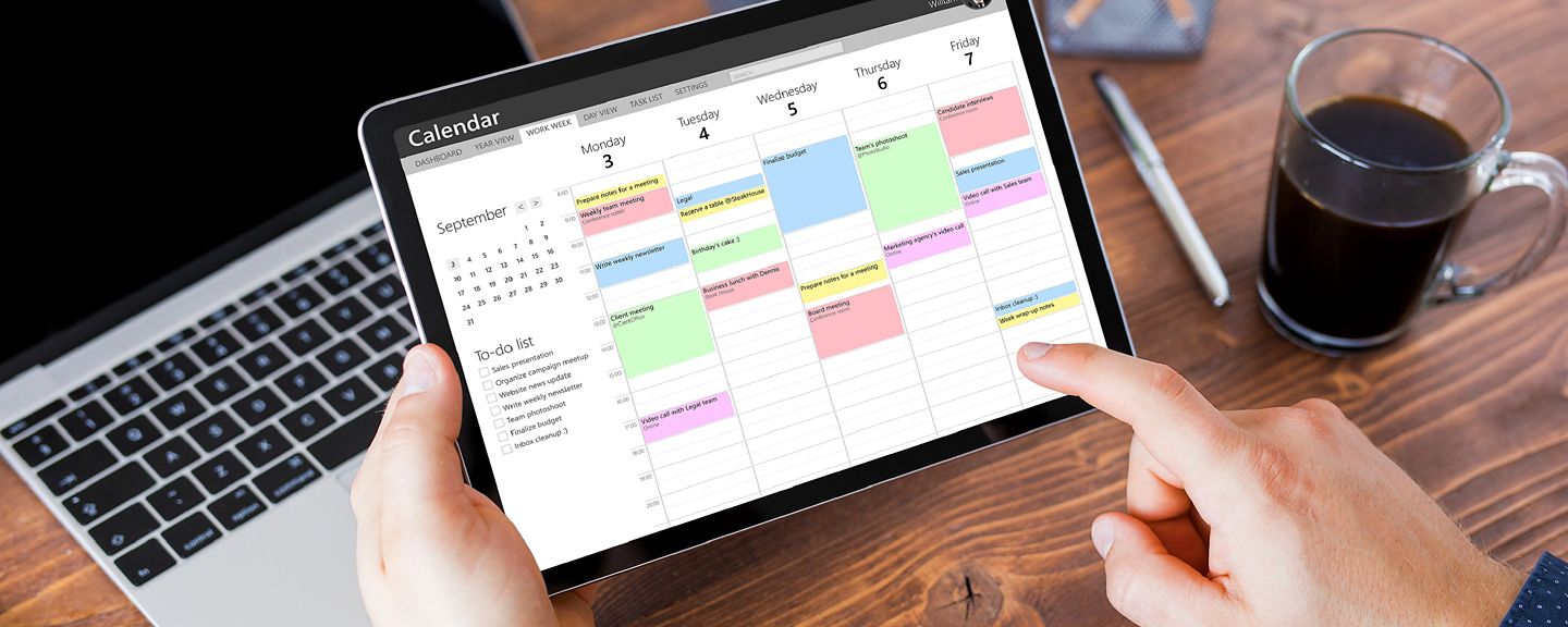 Man using calendar app on tablet in office