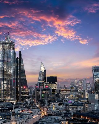 The City of London, financial district of the Metropole, just after sunset with illuminated buildings and cloudy sky, United Kingdom