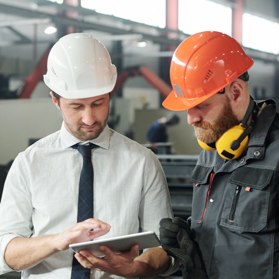  Two men in hard hats looking at tablet