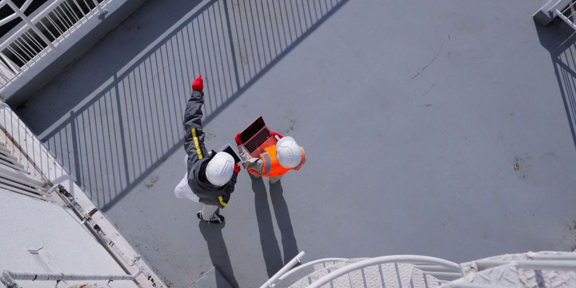 Aerial view of two workers in an industrial facility.