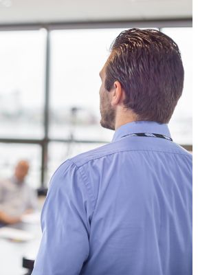 Business man making a presentation at office. Business executive delivering a presentation to his colleagues during meeting or in-house business training, explaining business plans to his employees. 