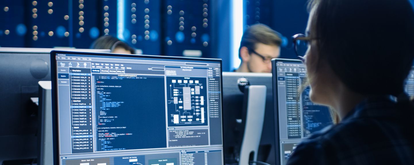 Smart Female IT Programer Working on Desktop Computer in Data Center System Control Room. Team of Young Professionals Doing Code Programming