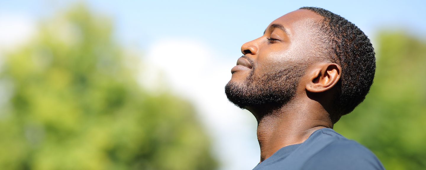 Profile of a black man breathing fresh air in nature