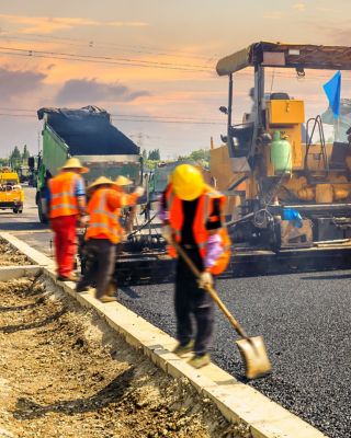 Construction site is laying new asphalt road pavement,road construction workers and road construction machinery scene.