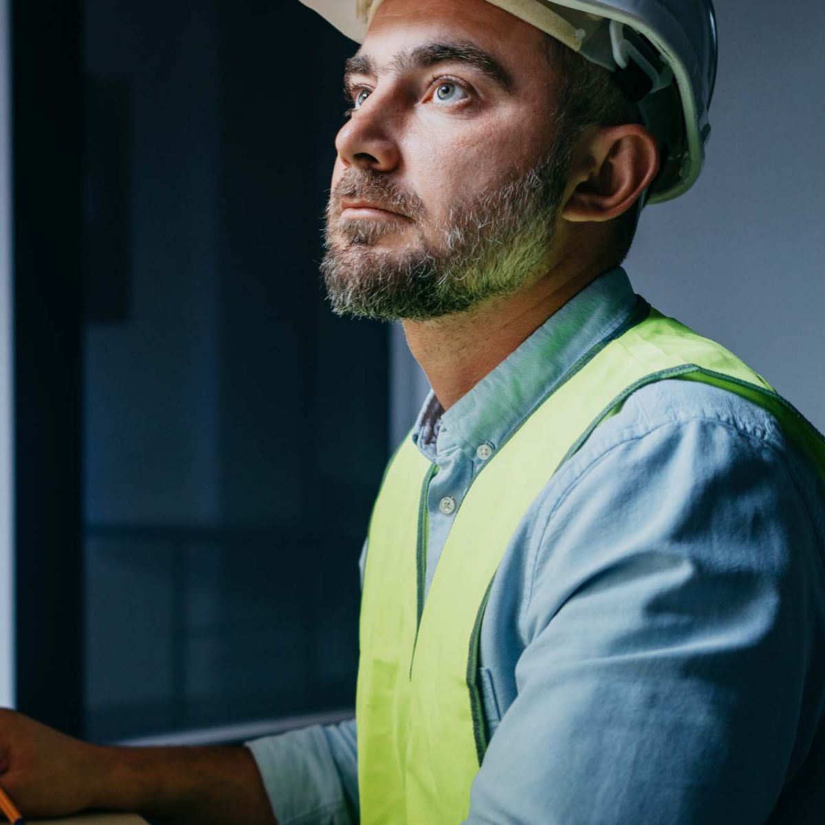 Bearded operator of factory control industry process using monitors. Engineer follow on production line