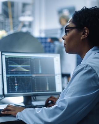 Female Engineer uses Computer to Analyse Satellite, Calculate Orbital Trajectory Tracking. Aerospace Agency International Space Mission: Scientists Working on Spacecraft Construction. Over Shoulder