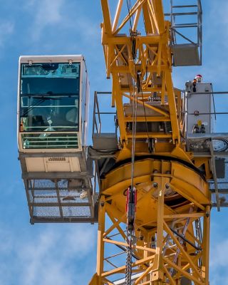 Close up details with a cabin control of a construction crane.Turret Slewing Crane against blue sky