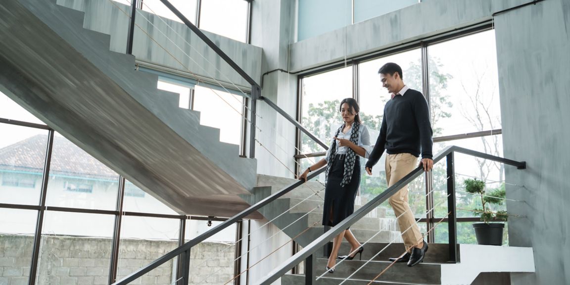 Professionals talking as they walk down stairs 