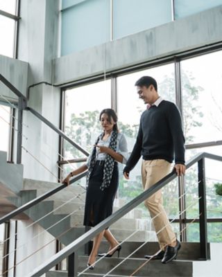 Professionals talking as they walk down stairs 