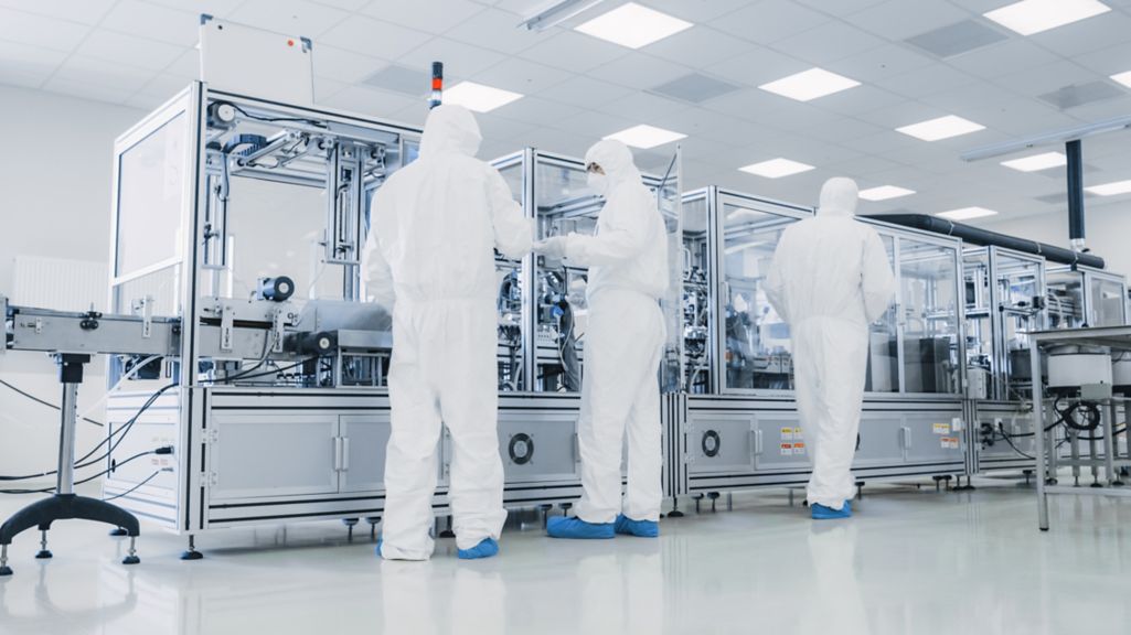 In the Manufacturing Facility Team of Scientist Wearing Sterile Protective Coverall Set's up / Programs Modern Industrial 3D Printer, High Precision Manufacture of Semiconductors under Process.