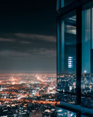 City building at night with view of lights from the city in the background