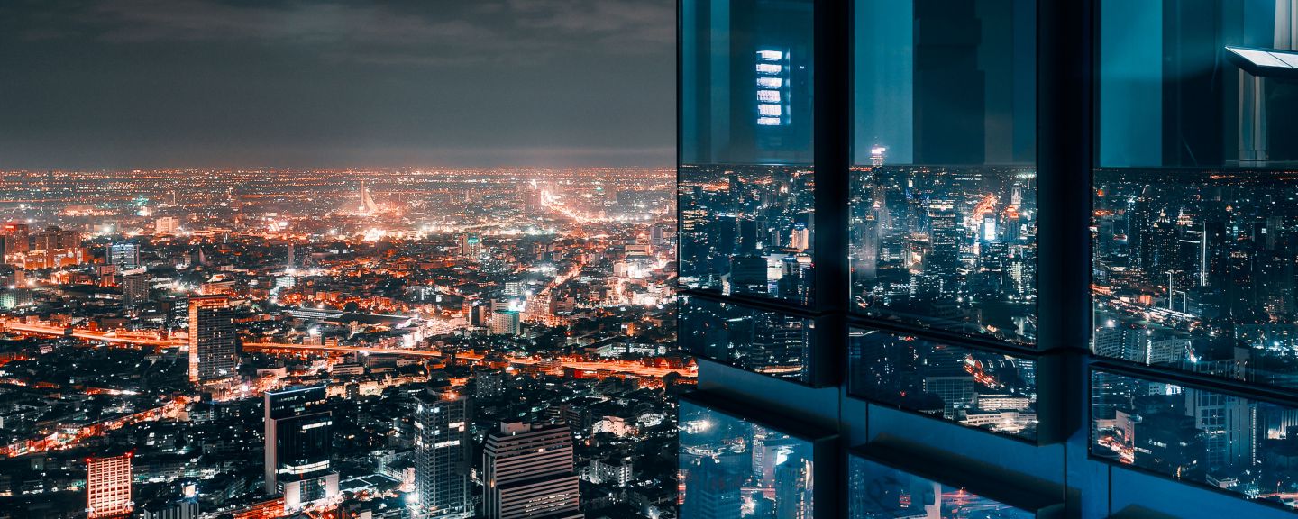 City building at night with view of lights from the city in the background