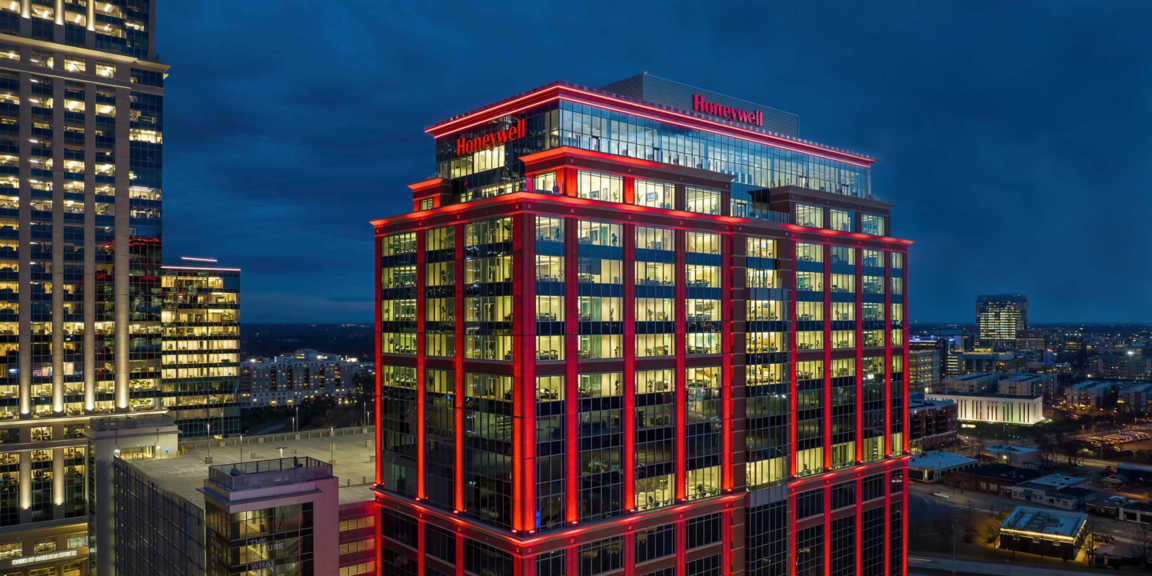 Honeywell headquarters office building at night with red LED lights and illuminated interiors in a city skyline.