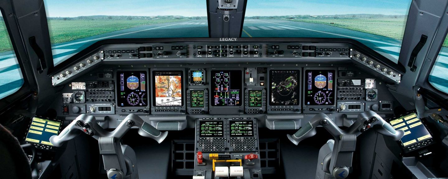 A pilot’s perspective from the cockpit, showcasing a serene green field stretching beyond the aircraft’s windshield under clear skies.