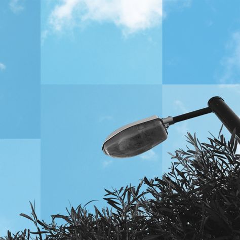 image of a street light set against a blue sky with clouds.