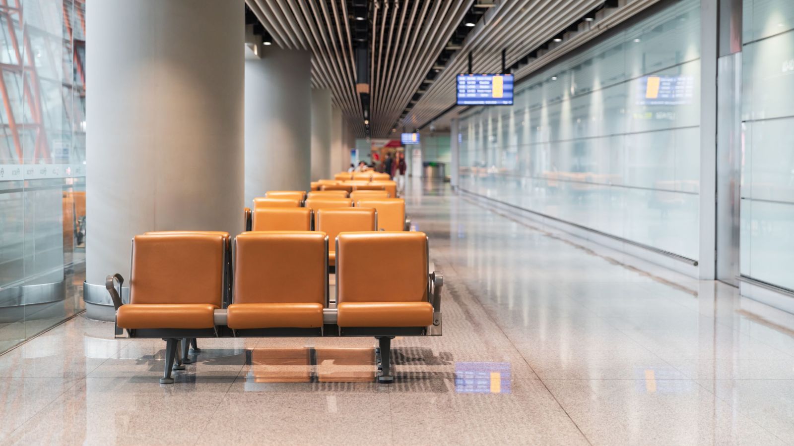 Spacious airport terminal featuring empty seating and 