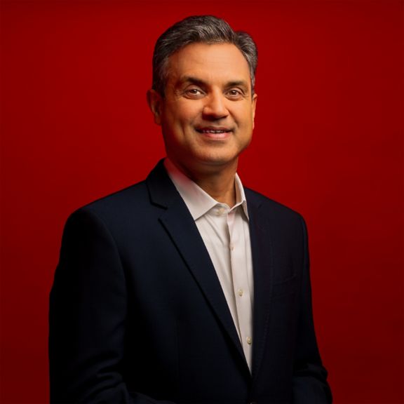 Professional portrait of Anant Maheshwari, captured against a bold red background.