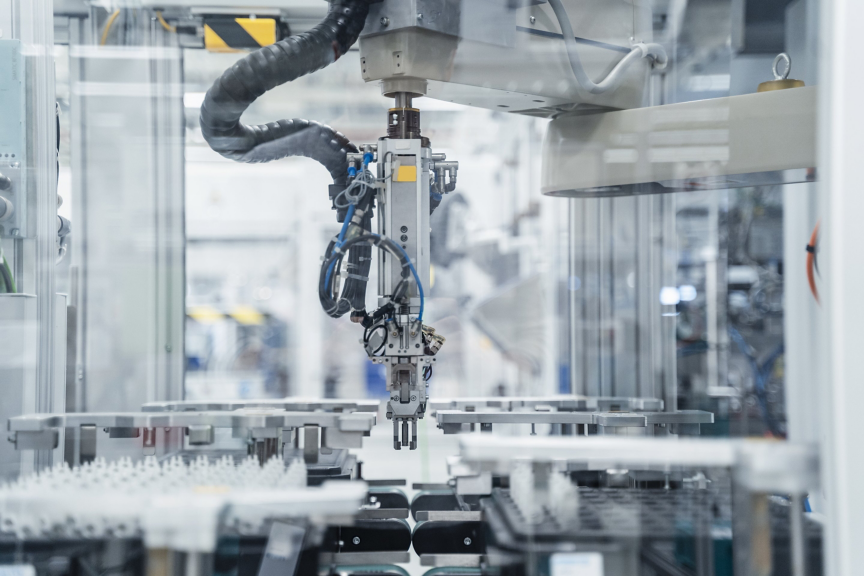 A high-precision robotic assembly arm operates within a clean, industrial manufacturing environment for automated production.