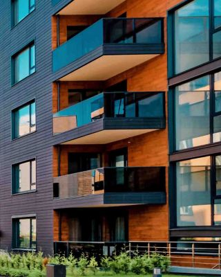Modern apartment buildings featuring contemporary architecture, balconies, and landscaped green spaces in a vibrant urban residential area.