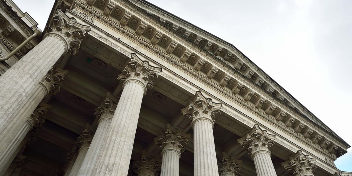 Intricate entablature rests atop tall, decorative Corinthian columns.