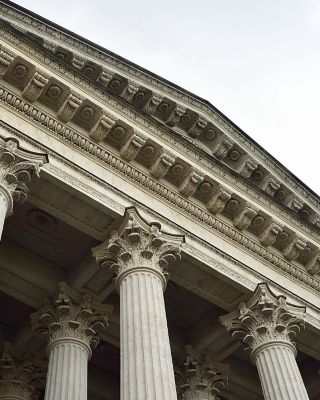 Intricate entablature rests atop tall, decorative Corinthian columns.