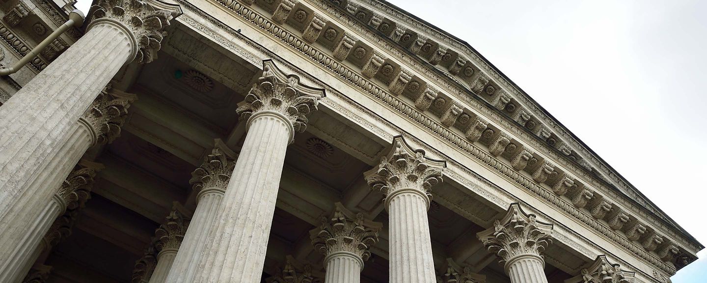 Intricate entablature rests atop tall, decorative Corinthian columns.