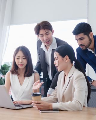 People meeting and talking by a computer