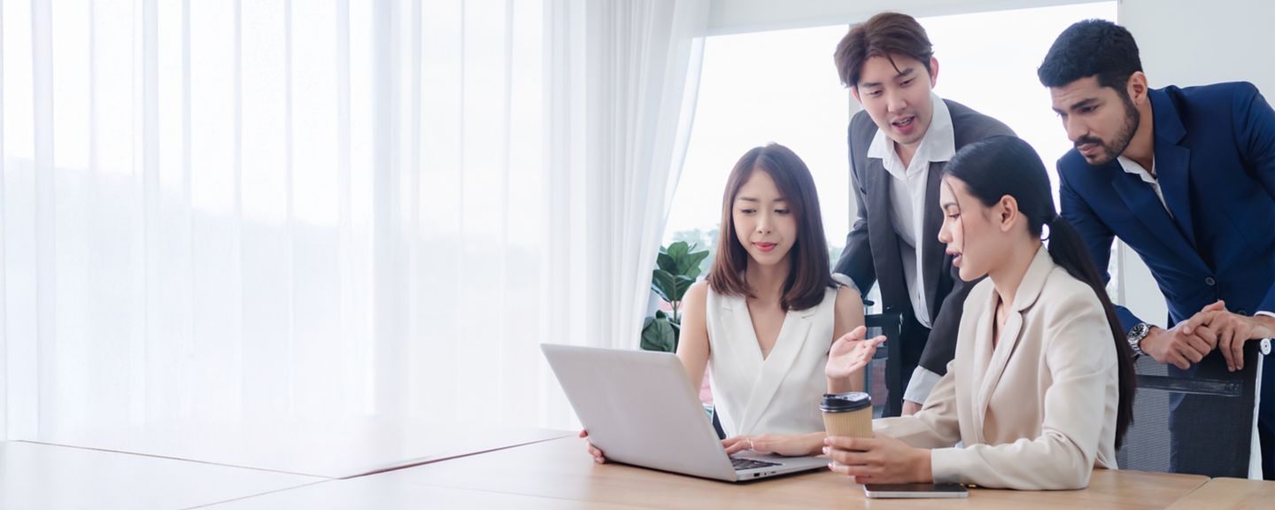 People meeting and talking by a computer