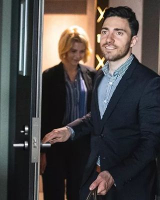 Man and woman entering a hotel room with bags