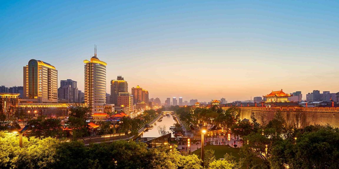 Beautiful evening view of Xian city wall with illuminated skyline, traditional architecture, and vibrant city lights in China.