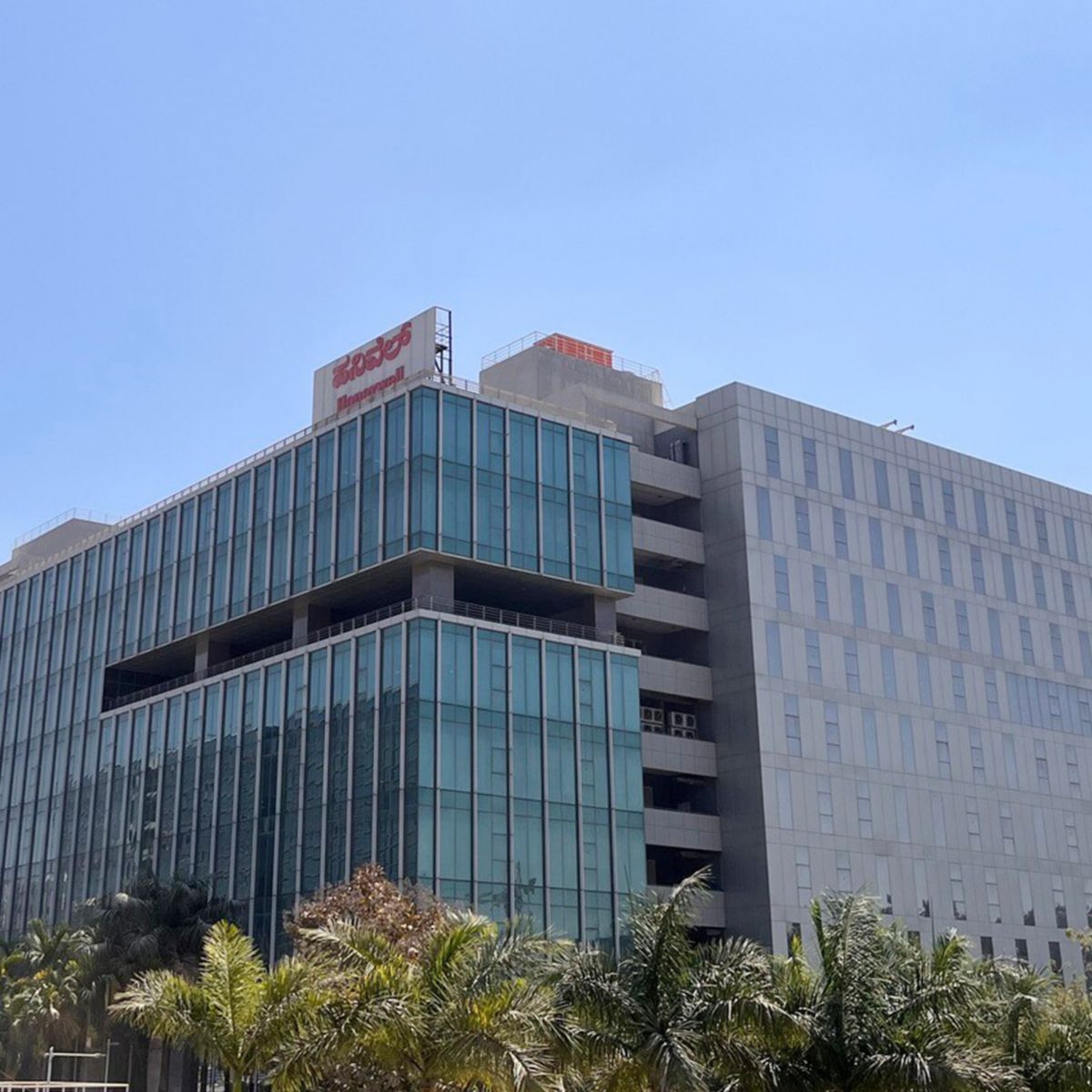 Contemporary office complex in Bangalore featuring glass facade and urban landscaping.