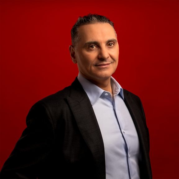 Professional portrait of Bilal Hammoud, captured against a bold red background.