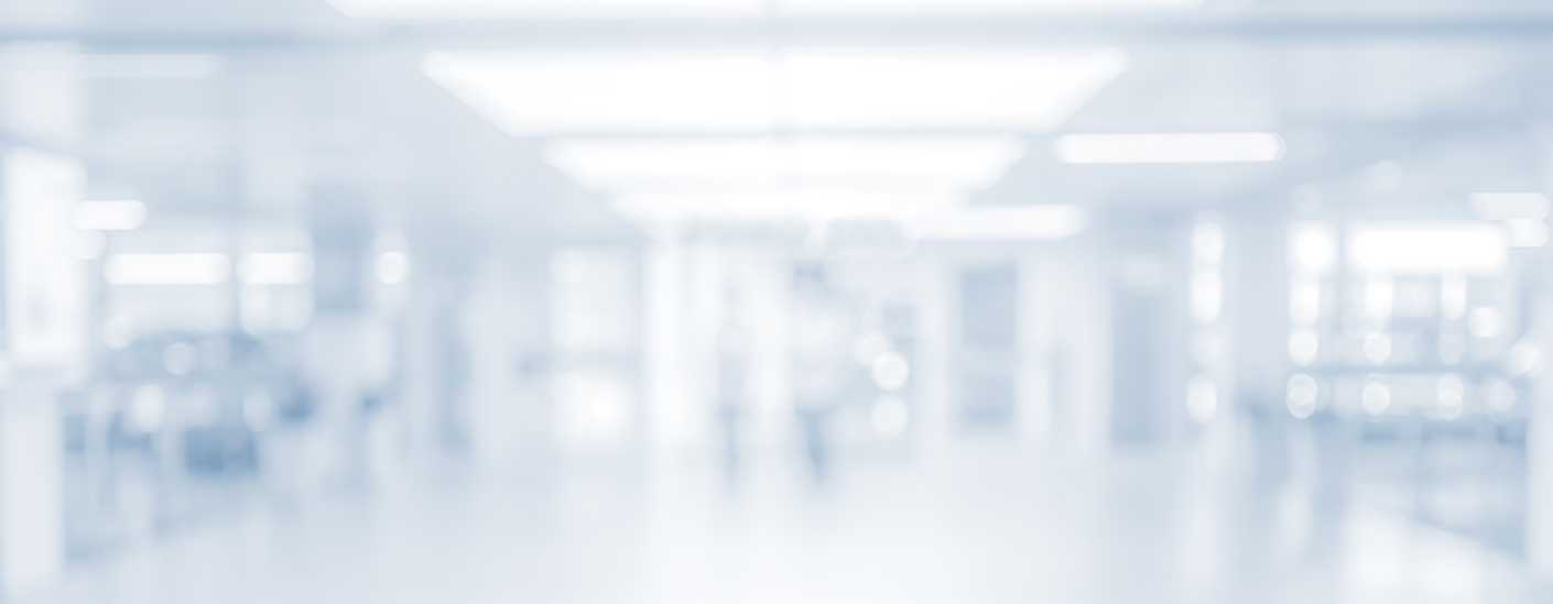 An empty hospital corridor appears softly blurred beneath bright ceiling lights.