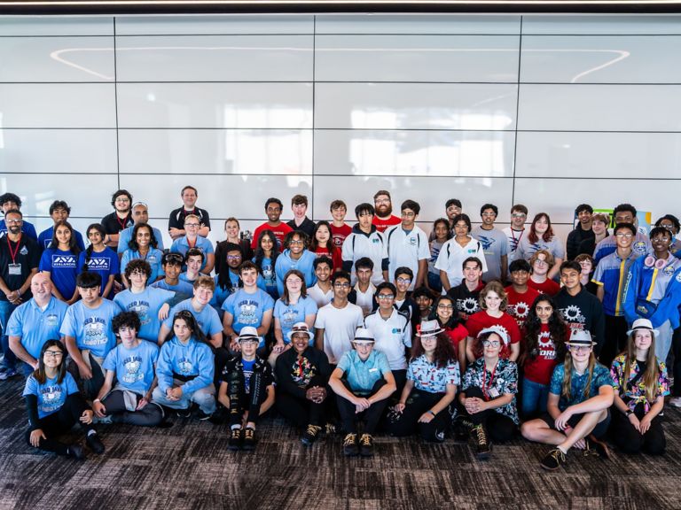 Portrait of a Group of Industrial Robotics Engineers Working on Humanoid Robot, Consulting with Specialists, Analyzing Electronic Components. Female Scientist Having a Meeting with Her Team.