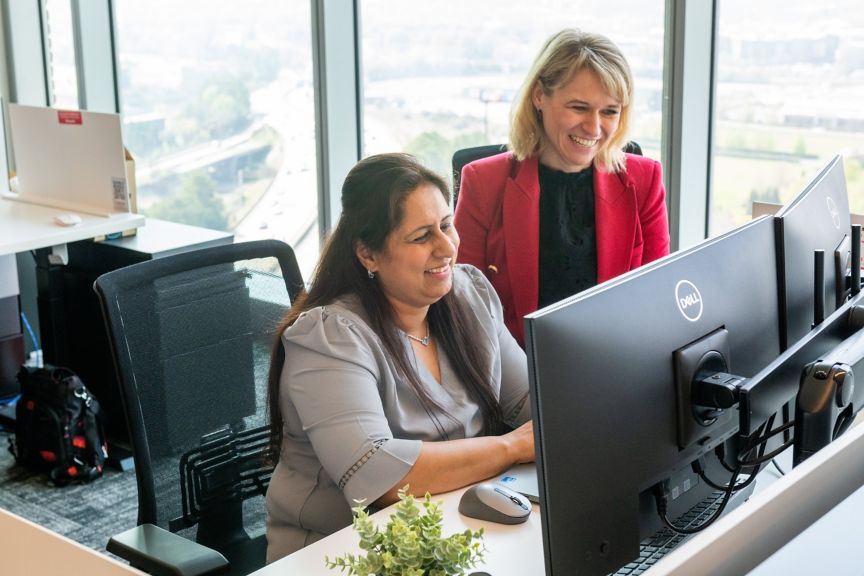Team Collaboration at Computer Desk in Corporate Office