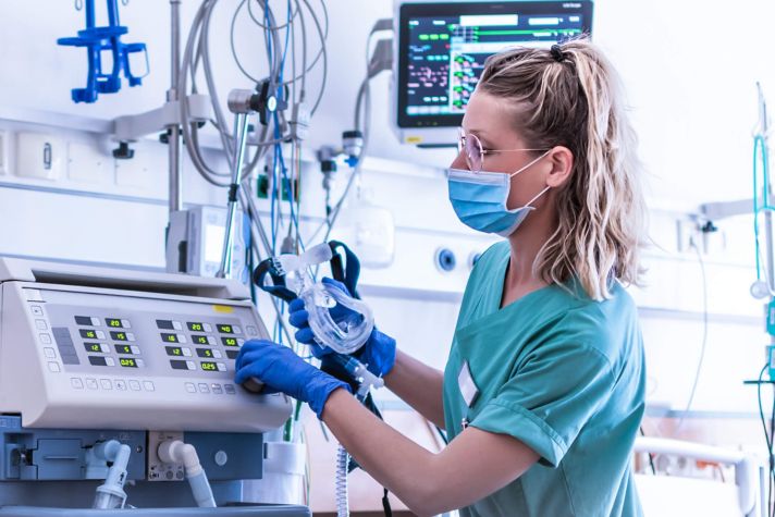Image a healthcare provider wearing personal protective equipment utilizing technology in a healthcare environment.