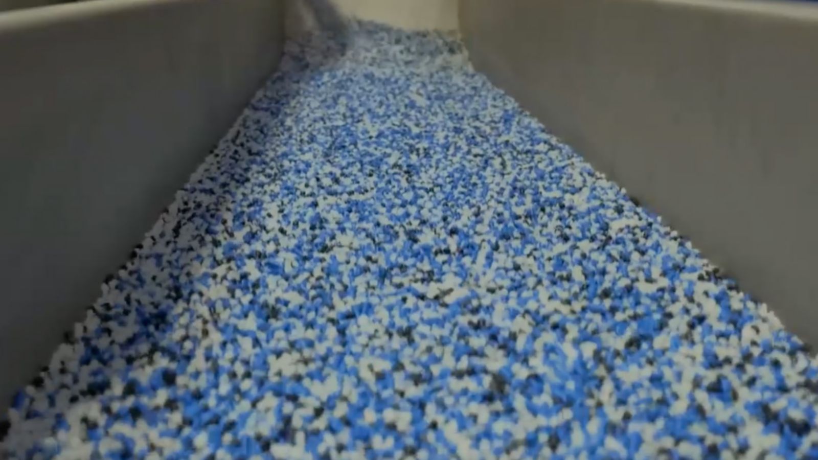 Witness the processing of materials in a state-of-the-art industrial facility. This image captures the efficiency of operations as blue and white materials are transported and prepared for further processing.