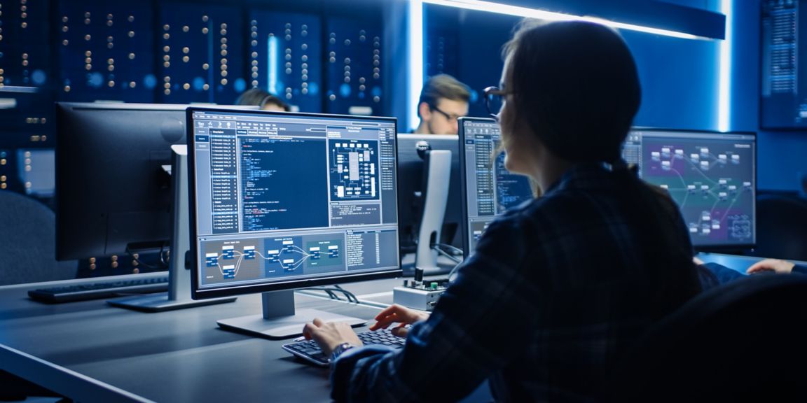 Smart Female IT Programer Working on Desktop Computer in Data Center System Control Room. Team of Young Professionals Doing Code Programming.