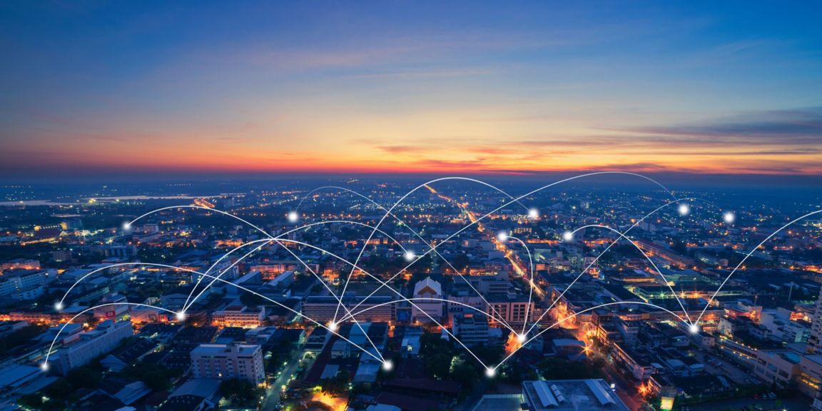 Aerial view of buildings and homes with illustrated lines representing power grid connection.