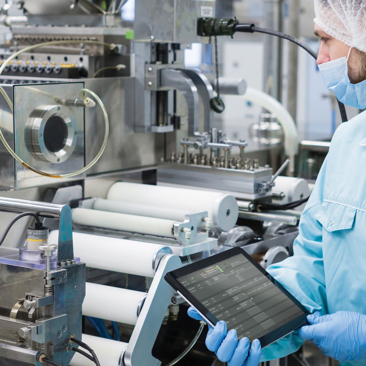 Lab worker with ipad in hand looking over equipment