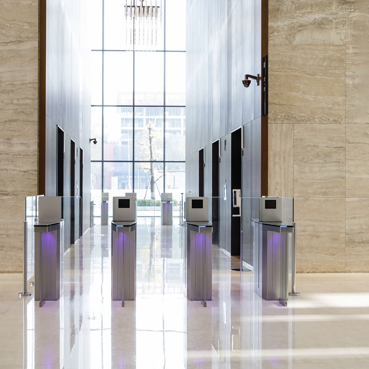 Four metal turnstile flanked by beige marble walls