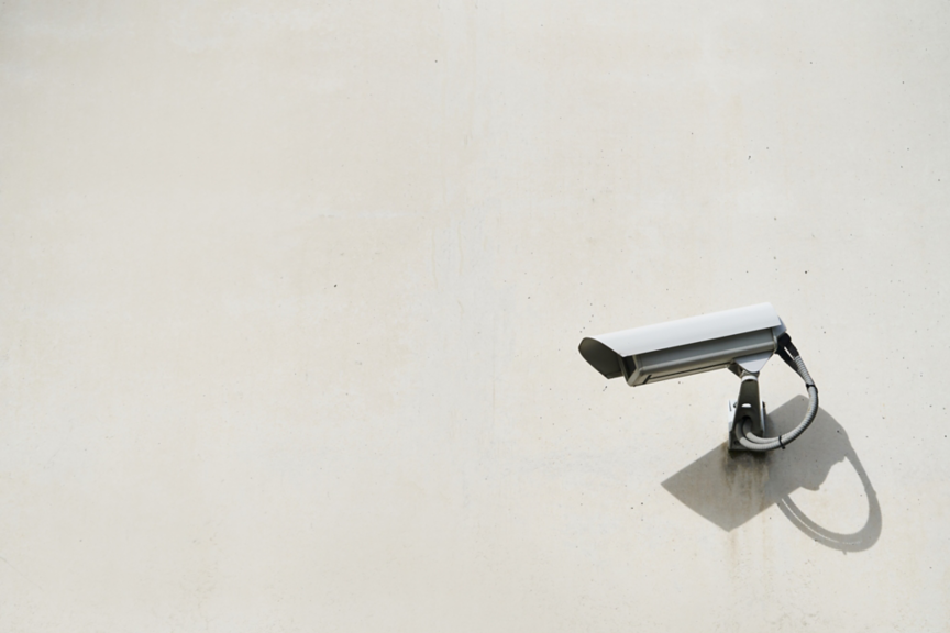 Close-up of a security camera hanging on the exterior wall of the building. Security concept.