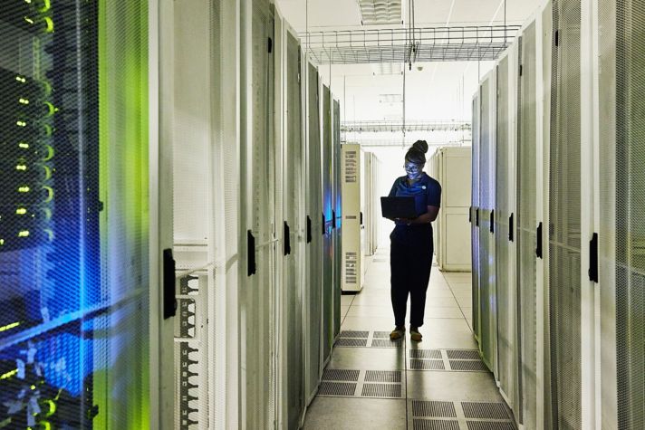 Computer engineer  between server racks in Data Center  