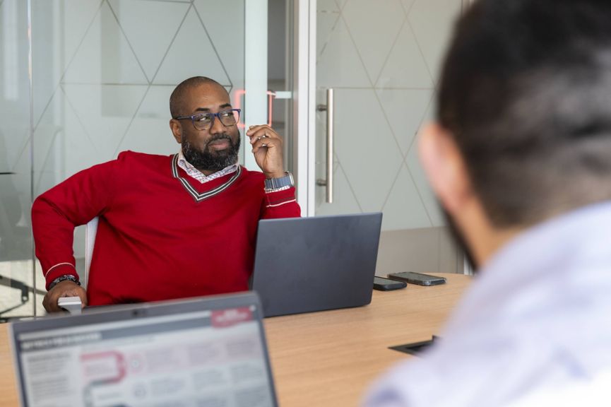 Employee engaged in a focused team discussion during a meeting, highlighting collaboration, communication, and decision‑making in a modern office.
