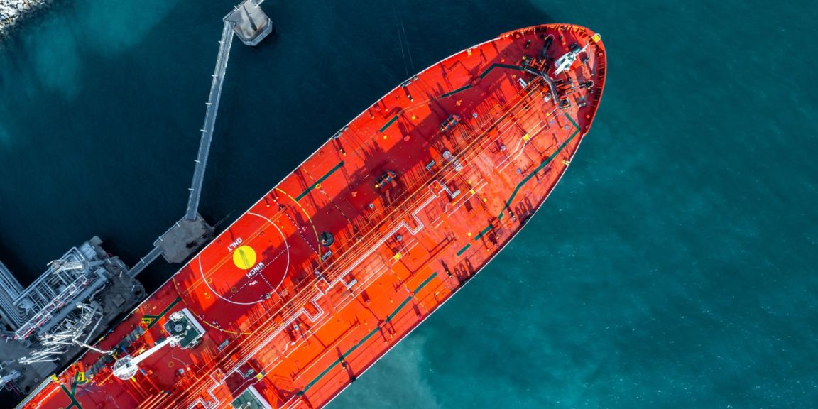 Aerial top view oil ship tanker vessel loading and unloading in oil terminal station refinery, Global business import export logistic transportation sea freight cargo tanker, Red crude oil tanker ship at port.